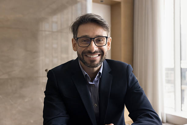 istock Businessman dressed in suit look at camera engaged in videocall 2240138054