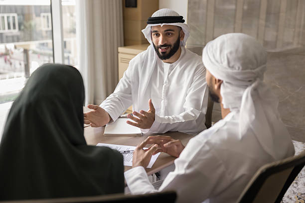 istock Arabian professionals dressed in traditional Muslim robe discussing contract details 2240139446