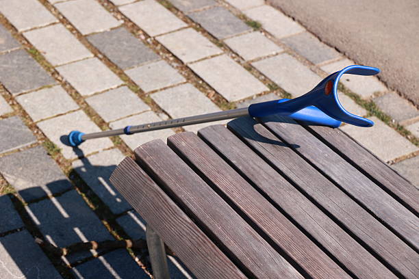 Young woman enjoying with keeping company to older man with disability outside in the city public park