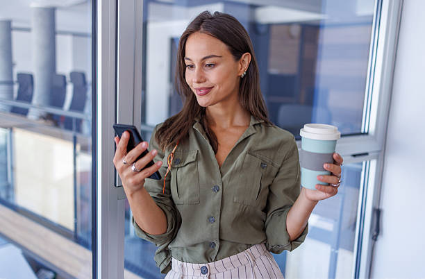 istock Young businesswoman checking phone during office coffee break 2240140967