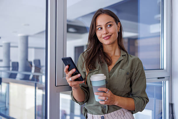 istock Businesswoman taking coffee break thinking with phone 2240140993