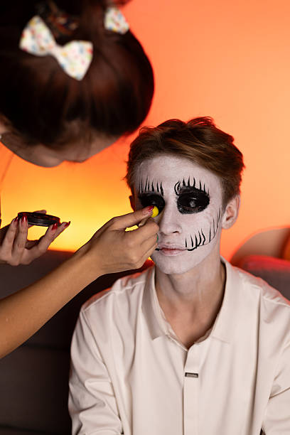 istock a young guy gets Halloween makeup as a scary skeleton. 2240141134