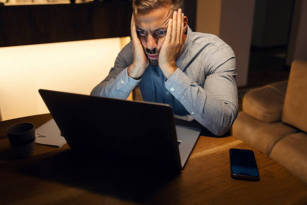 istock Stressed man working late on laptop at home 2240141684