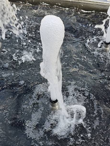 A dynamic water fountain captures flowing water with charming bubbles and splashes. This urban setting showcases the beauty and relaxation of outdoor water features.