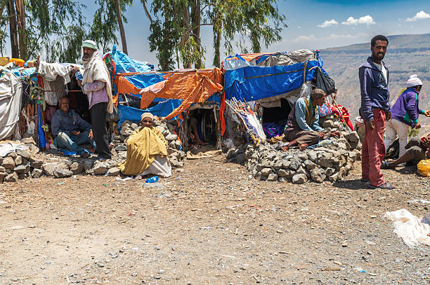 ChAgel AmanuEl Bete Kristiyan, Oromia region, Ethiopia - April 19 2019: Local people gather outside improvised shelters at ChAgel AmanuEl Bete Kristiyan in the Ethiopian highlands.
