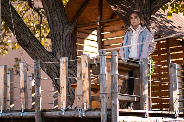 istock Young girl reflecting in rustic treehouse during autumn 2240153065