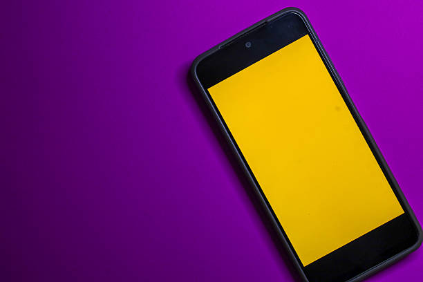 This minimalistic shot shows a smartphone with a bright yellow screen, positioned diagonally in the bottom right corner.