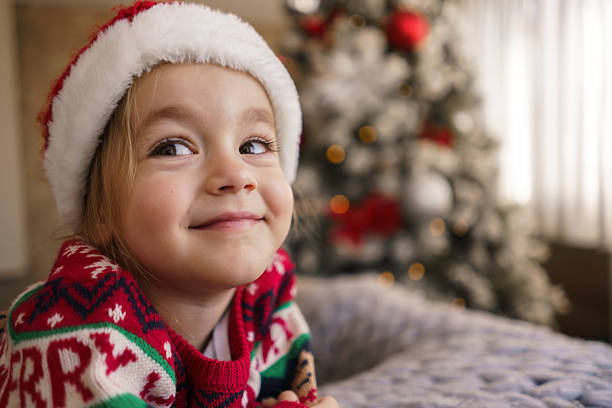 istock Young child wearing Santa hat and Christmas sweater smiling 2240155872