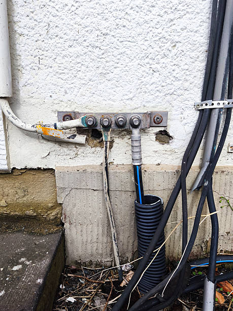 istock Electrical grounding connection terminal outside on rough white stucco wall close up 2240161423