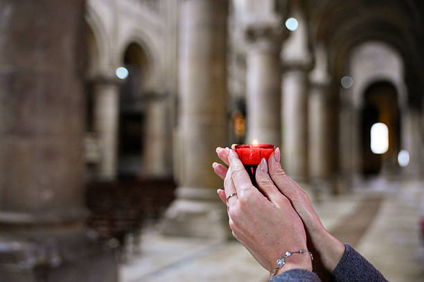 Person holding candle in church symbolizing faith and hope