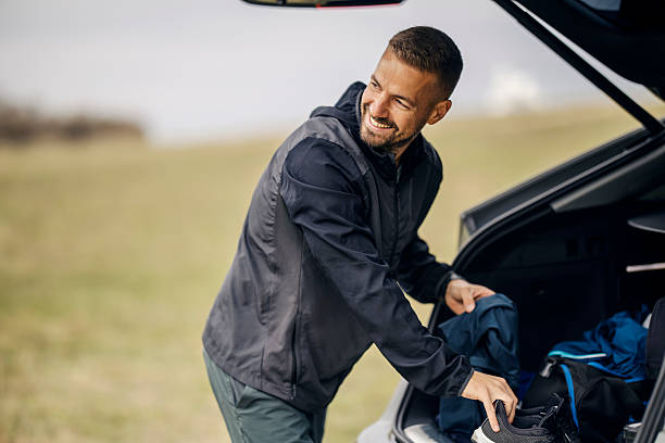 istock Man packing car trunk for a sport road trip 2240164896