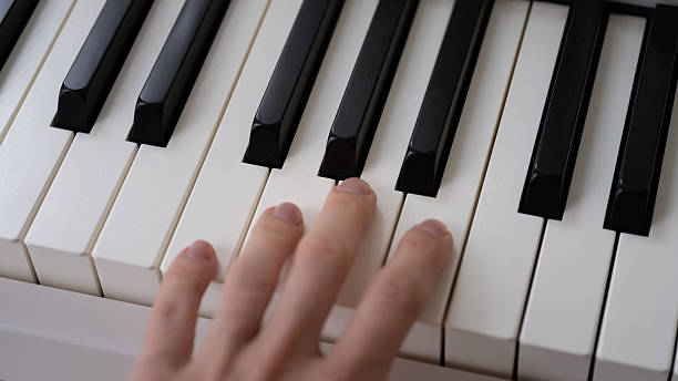 istock Hand playing keys on digital piano keyboard 2240167360