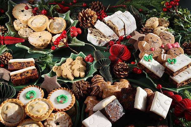 Image of festive christmas party food platter, cakes, mince pies, gingerbread men, stollen / holiday buffet dessert selection, xmas celebrations stock photo