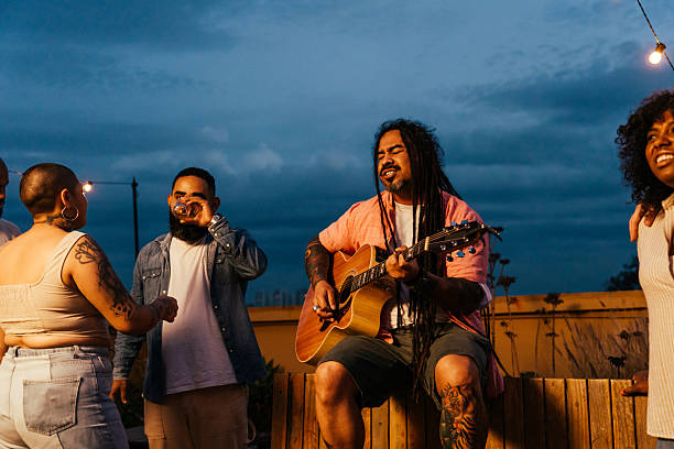 istock Man playing guitar for friends at happy hour 2240171342