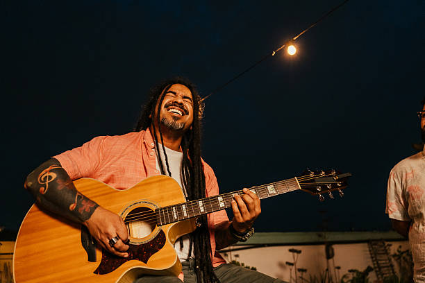 istock Man playing guitar for friends at happy hour 2240172270