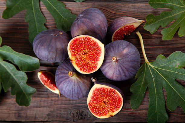 istock Ripe figs with leaves on rustic wooden background 2240172313
