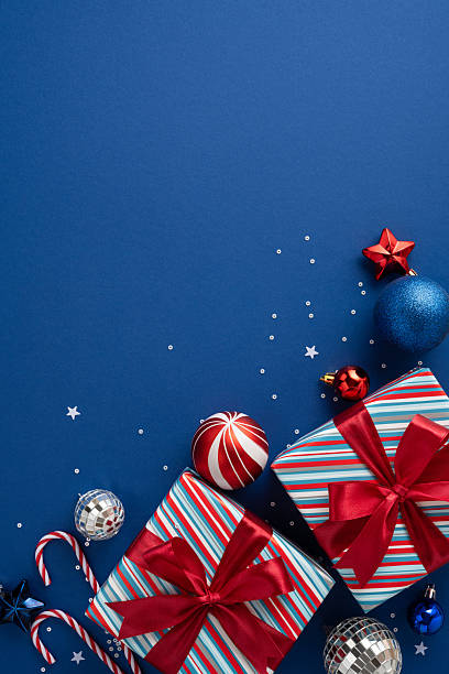 istock Bright vertical blue background with striped gift boxes, red bows, ornaments, and candy canes creates a cheerful Christmas and New Year mood, perfect for holiday greetings and seasonal decor 2240173110