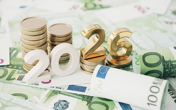 Gold Colored 2026 text and stack coin over 100 Euro Bills