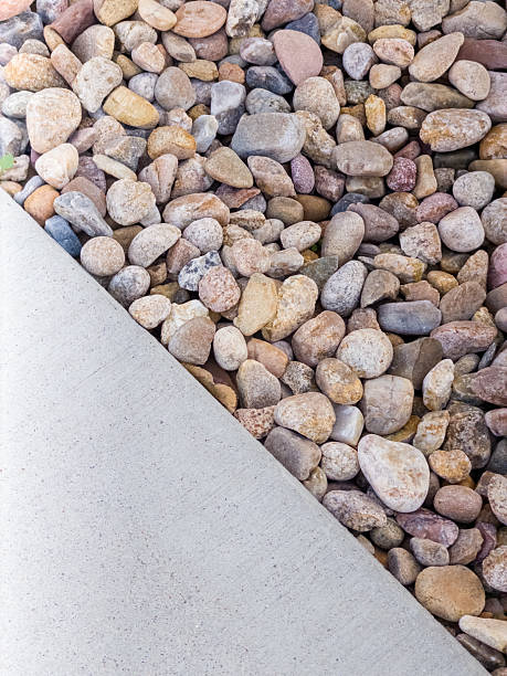istock Concrete pathway meeting river rock landscaping abstract texture 2240176334