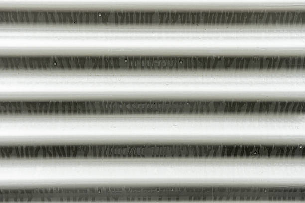 Gray metal wavy surface filled with rain water drops