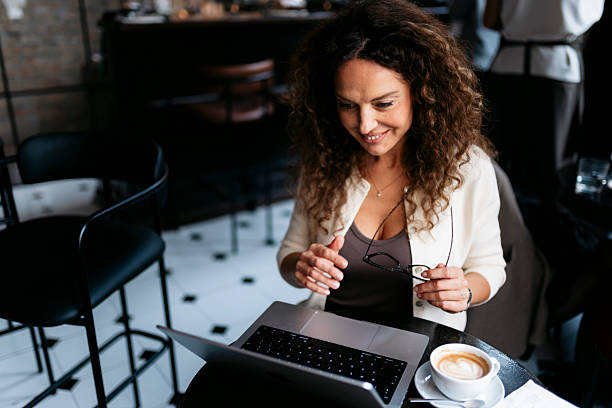 istock Woman working on laptop in cafe with coffee 2240179617