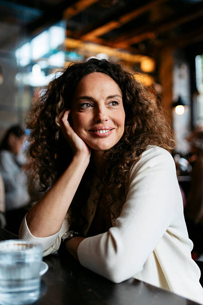 Woman daydreaming and smiling in cafe