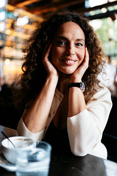 istock Woman smiling at camera enjoying coffee break in cafe 2240179704