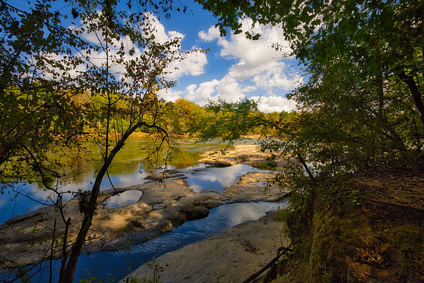 A nice summer view looking down at the Cape Fear River and its unique rock formations from the Fish Traps trail at Raven Rock State Park in Lillington North Carolina under a cloudy blue sky..