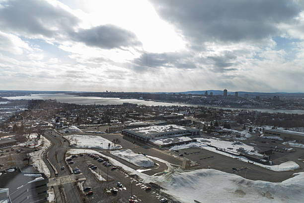 istock Aerial Winter Cityscape Over Snowy Suburbs, River, and Sun Rays Breaking Through Clouds 2240194601