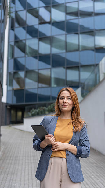 istock Confident Professional Woman in Urban Setting with Tablet 2240198157