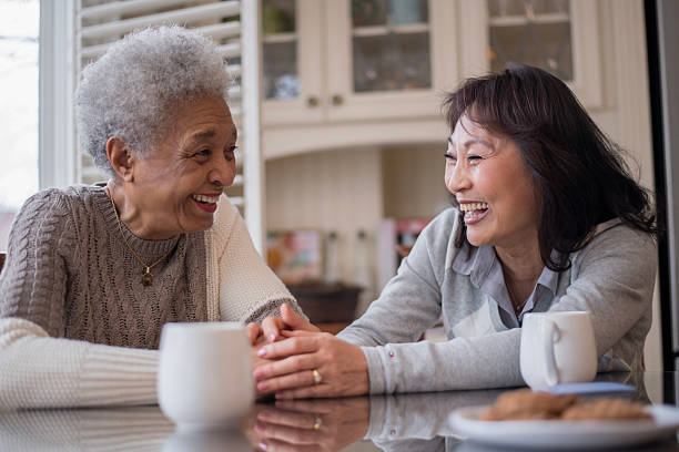 istock Senior Friends Enjoy Warm Conversation At Kitchen Table, Sharing Laughs And Tea Moments 2240204563
