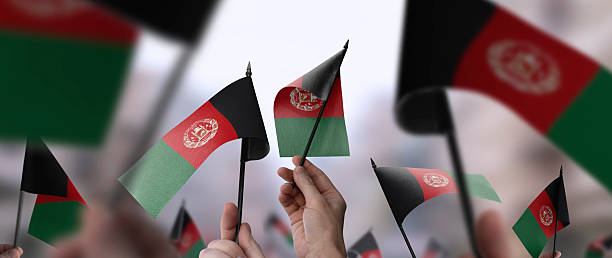 istock Afghanistan flags in their hands on a blurred urban background 2240206052