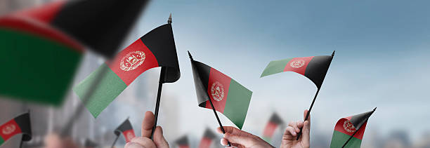 istock Afghanistan flags in their hands on a blurred urban background 2240206060