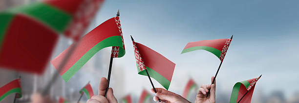 istock Belarus flags in their hands on a blurred urban background 2240206160