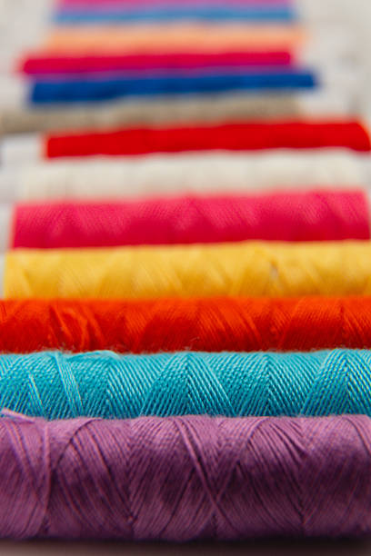 istock Colorful spools of thread arranged in vibrant stripes on a table 2240206254