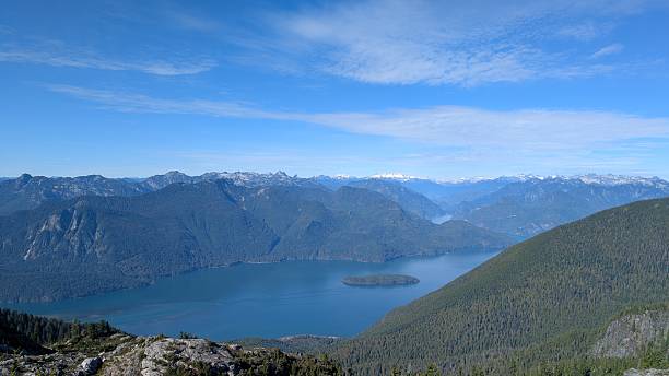 istock Panoramic Fjord (Pitt Lake) Landscape – Snow-Capped Mountains, Deep Blue Water, and Forested Slopes Viewed from Rocky Vantage Point 2240208569