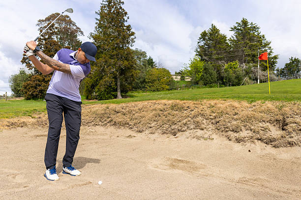 Golf ball explode from sand bunker. Golfer hit ball with club to sand explosion to green. Golf club hit ball in sand bunker explosion. White background isolated freeze motion