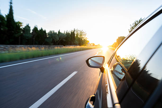 istock Car driving on open road during sunset golden hour 2240211386