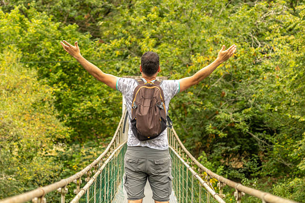 istock Tourist enjoying scenic view on hanging bridge over river 2240213193