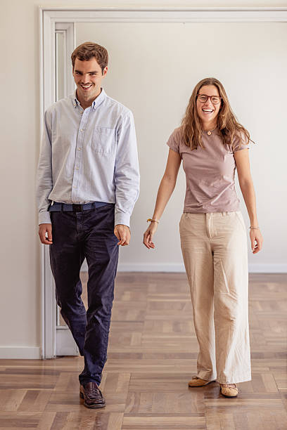 istock Young couple smiling, moving into new empty apartment 2240215434