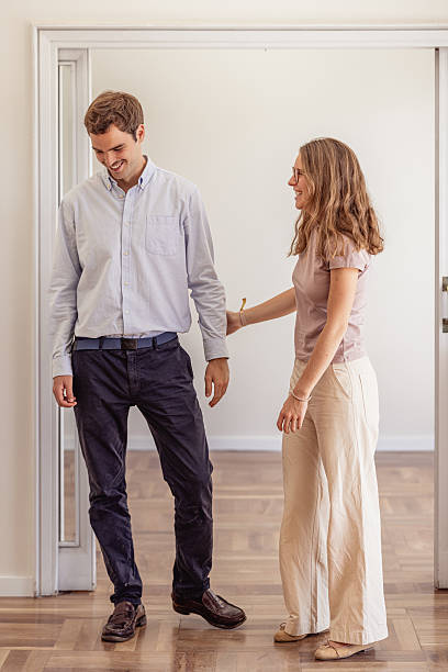 istock Young couple smiling, feeling happy moving into their new empty apartment 2240215435