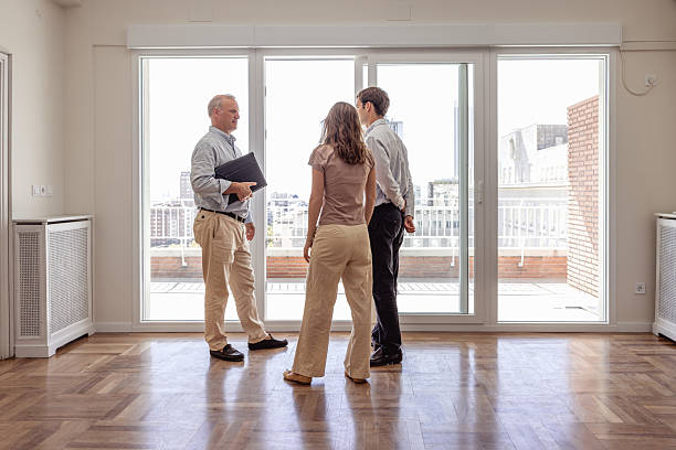 istock Real estate agent showing views from empty apartment to young couple 2240215518