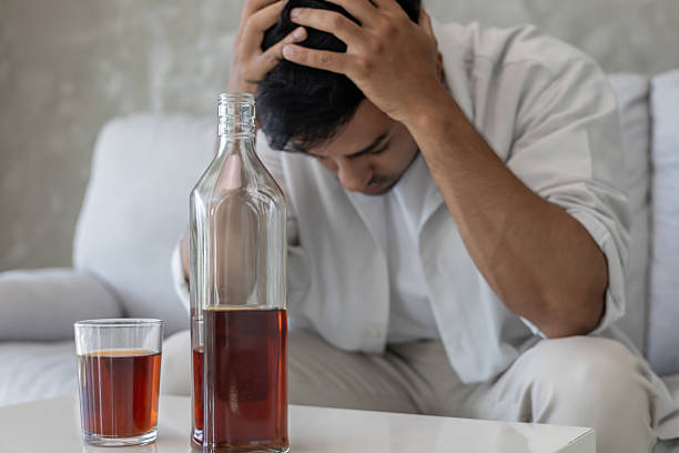istock Depressed young Asian man addicted feeling bad drinking whiskey alone at home, stressed frustrated lonely drinking alcohol suffers from problematic liquor, alcoholism, life and family problems 2240215878