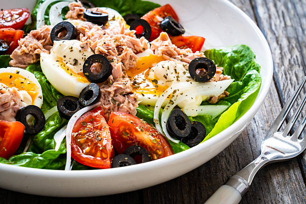 istock Tuna, boiled eggs and vegetables on wooden background 2240216306