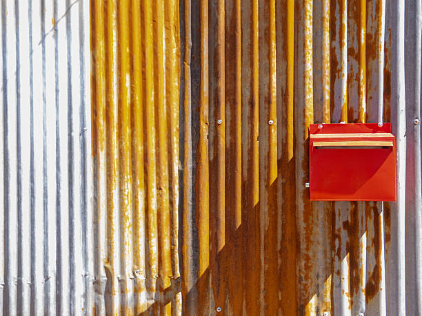 istock Zinc weathered wall with some rust stain and a red letter box. 2240220090