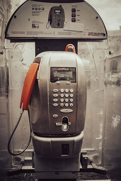 Castel Volturno, Caserta - November 2023. A modern Telecom Italia payphone in the city center, one of the last models released before the widespread advent of cell phones. Equipped with a keypad, digital screen, and orange handset, it represents a fragment of the recent past, a silent witness to millions of conversations now superseded by mobile technology.