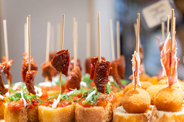 Basque pinchos (form of Spanish tapas), with bread and Spanish ham, in a bar. Typical snack of Basque Country, pinchos or pinxtos skewers.