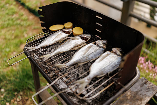 High angle shot of four sea breams on grill in nature without people