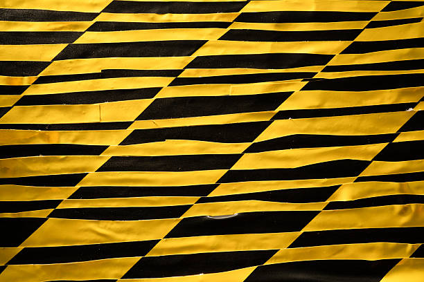 Yellow and black wobbly and slanted grid created from old barricade tape