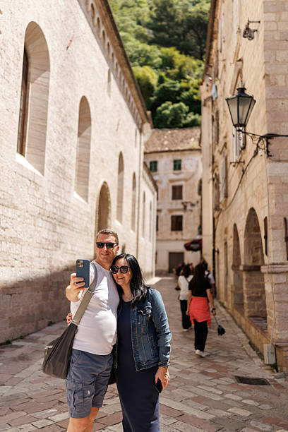 istock Happy mature couple taking selfie on smart phone while exploring old coastal town during vacation 2240224661